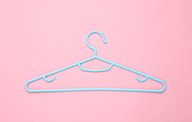Blue Plastic hanger on pink background. Fashion layout. Flat lay. Top view