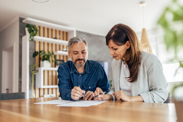 Brunette woman, signing contract with one male client.