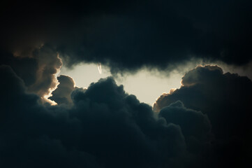 Airplane with smoke trails in the storm clouds.