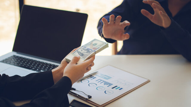 Businessperson refusing bribe given money  by Colleague with anti bribery corruption concept.