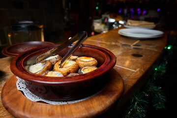 Champignons in sour cream sauce baked in ceramic dishes. Close-up, selective focus