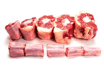 Raw uncooked beef oxtail cut into portions on white isolated background. Butcher craft. Meat industry product. Soup and stew ingredient