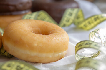 tape measure and donuts or industrial pastry, diet and food concept