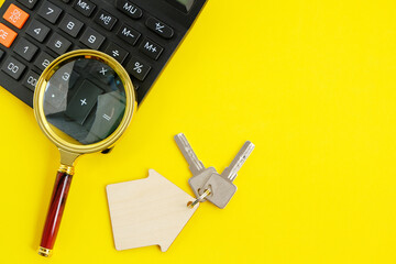 Calculator Magnifier and House Keys Concept of Buying and Selling Housing Mortgages and Renting a House or Apartment