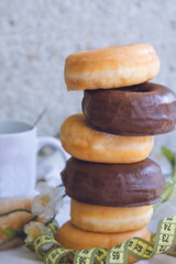 tape measure and donuts or industrial pastry, diet and food concept