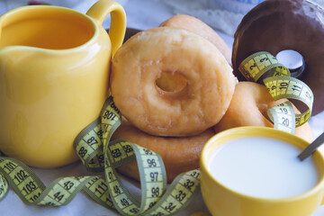 tape measure and donuts or industrial pastry, diet and food concept