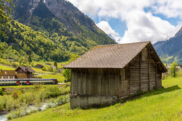 Swiss hut on a farmland with a view to a train station in Glarus