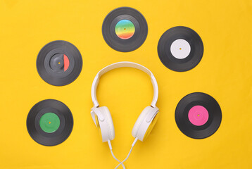 Musical layout. Headphones and vinyl records on yellow background. Top view. Flat lay