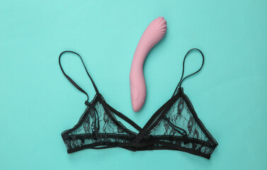 Black bra and sexy toy on blue background. Top view