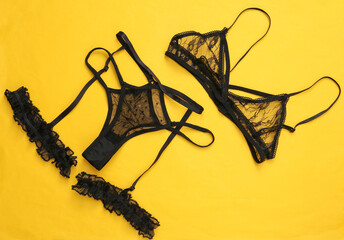 Fototapeta na wymiar Set of black sexy lingerie on yellow background