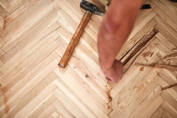 Repairman restoring old parquet hardwood floor.