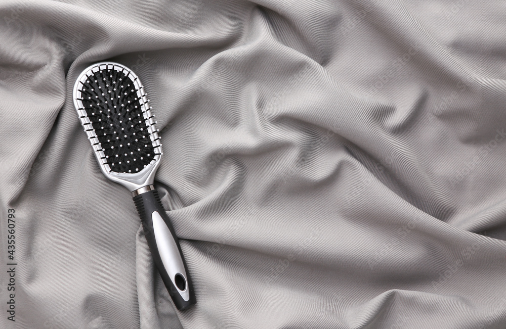 Wall mural Hair brush on a gray silk background. Beaty still life