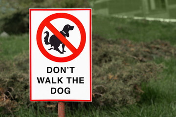 don't walk the dog sign on the Green lawn in the park. No Dogs Walking on the street. you can not walk with a puppy