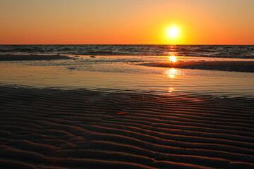 Sandy waves with sunset on Florida beach, US