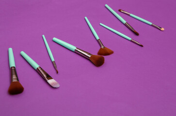 Makeup brushes on purple background. Beauty layout.