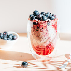 Healthy chia pudding in a glass with fresh blueberries