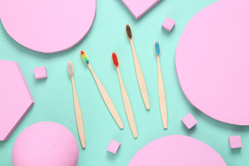 Eco-friendly bamboo toothbrushes with pink different geometric shapes on blue background. Minimalism. Creative layout