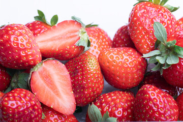 Macro photograph of a plastic box full of strawberries on white. selective focus