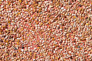Texture of small stones, rocky abstract background, grainy surface, gravel pattern, red pebbles. Decorative design, brown colored. Grunge wall backdrop.
