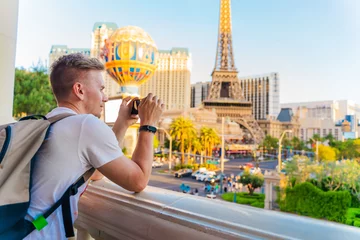 Foto auf Acrylglas Las Vegas Ein junger Mann fotografiert ein Panorama der Stadt mit den Gassen von Las Vegas