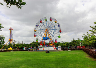 Multicolor Ferris wheel in public/water park. Far view. Telangana Hyderabad Tourism.