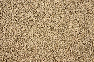 Image of the surface of the sand after rain has porous rain marks

