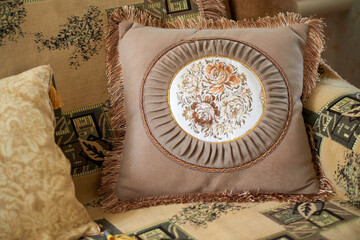 Decorative pillow with a fringe and an embroidered panel depicting roses