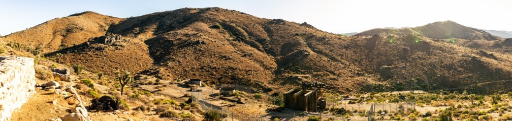 Medium shot of abandoned gold mnine and hills in desert of Joshua tree national park in america at sunset