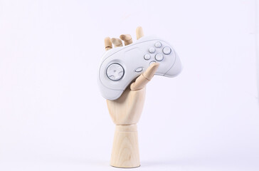 Wooden hand holding gamepad on white background