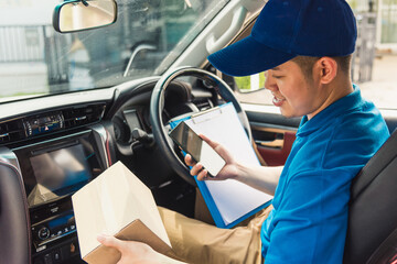 Asian delivery man courier online holding deliveries out boxes inside the car and using mobile smartphone checking location to contact the customer for shipment, Online shopping service concepts