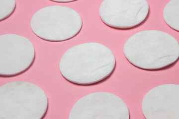 Cotton pads on a pink background. Personal hygiene concept. Cotton wool products