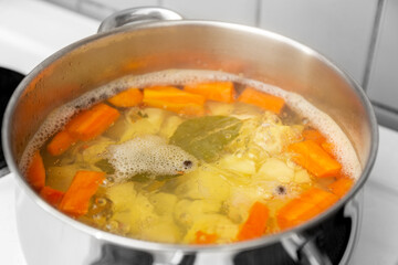 The chef cooks Finnish salmon soup soup is cooked in a saucepan.