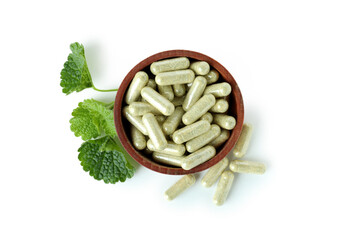 Bowl with herbal powder capsules isolated on white background