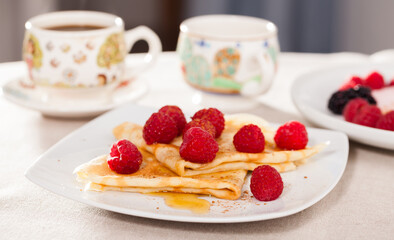 breakfast of pancakes with fresh raspberries on table