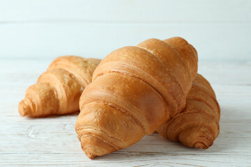 Croissants on white wooden background, close up
