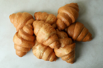 Tasty croissants on white textured background, top view