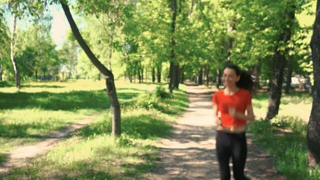 A young woman runs along the path stops and regains her breath