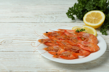 Plate with tasty shrimps on white wooden table