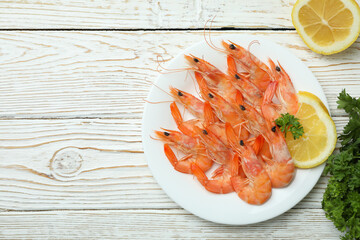 Plate with tasty shrimps on white wooden table
