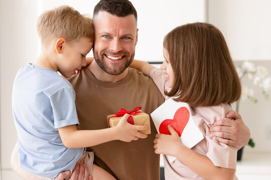 Cute children son and daughter congratulating dad with Fathers day in morning at home