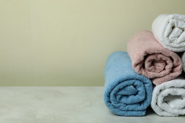Clean rolled towels against beige background, space for text