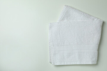 Clean folded towels on white background, space for text