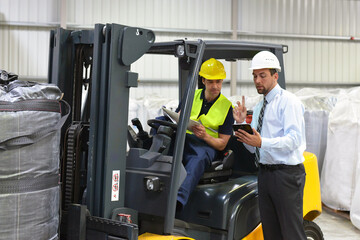 Arbeiter in einer Industriehalle - Logistikbereich chemieunternehmen - Gabelstapler und Ölfässer