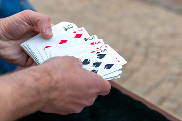 Man holding playing cards in his hands. Excitement, addiction to playing cards.
