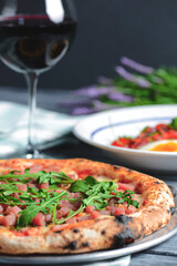 Tuna salad with vegetables, boiled eggs, cherry tomatoes and spices. Pizza with salmon fish, cheese and fresh arugula