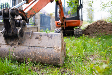 Mini excavator in orange color. construction equipment rental