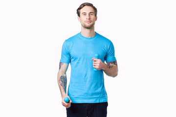 Fototapeta premium athlete with dumbbells on a light background and blue t-shirt pants tattoo