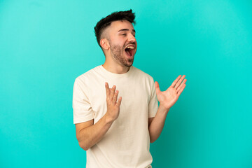 Young caucasian man isolated on blue background with surprise facial expression