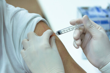 Close-up view of covid-19 vaccination on a man left arm