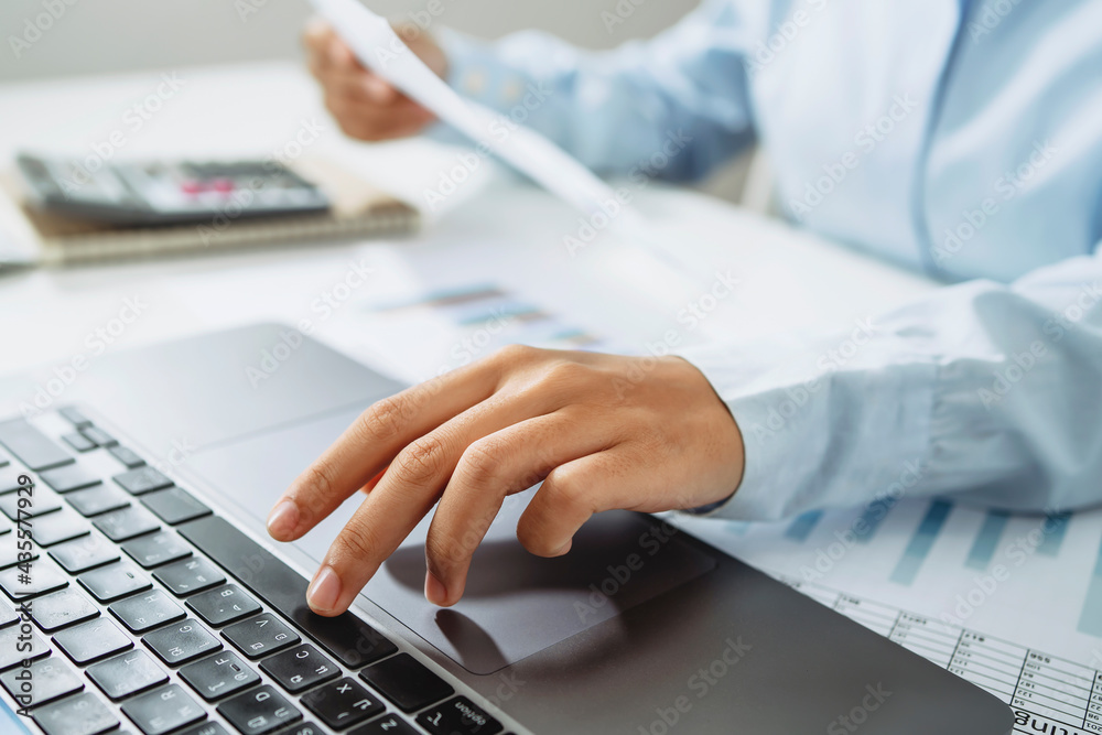 Poster accountant use calculator and computer with holding pen on desk in office. finance and accounting co